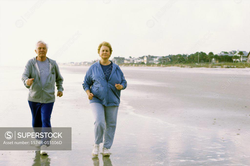 Stock Photo: 1574R-015106D Senior couple jogging on the beach