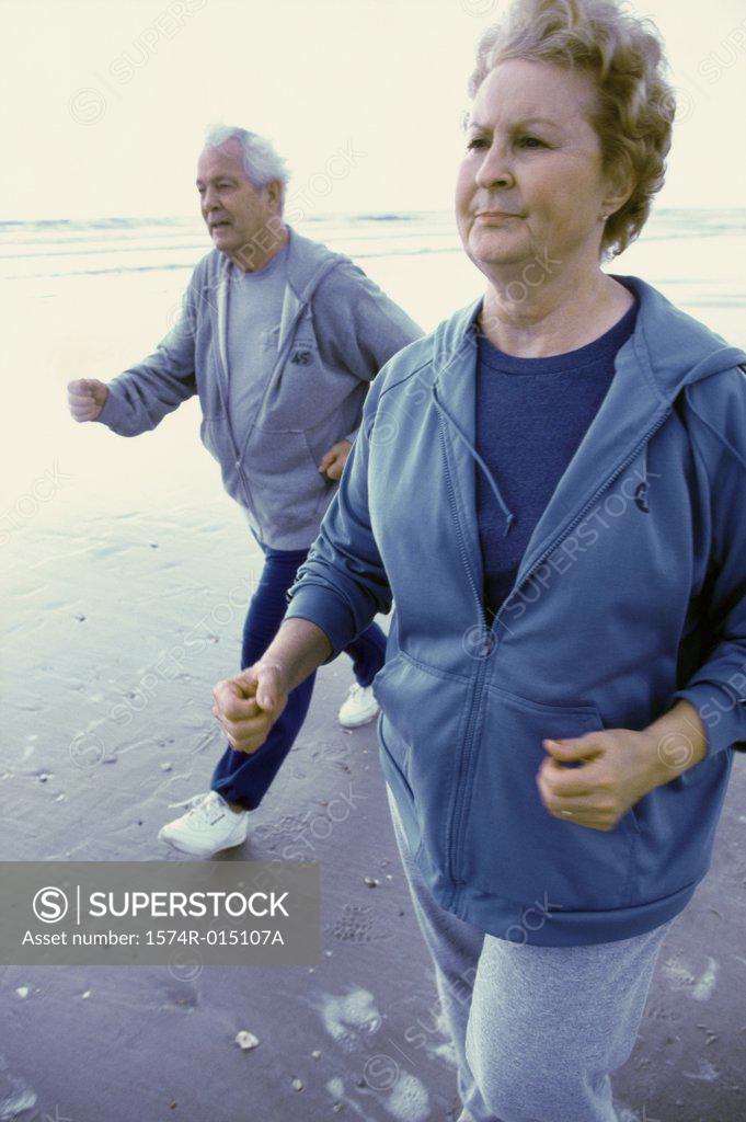 Stock Photo: 1574R-015107A Senior couple jogging on the beach