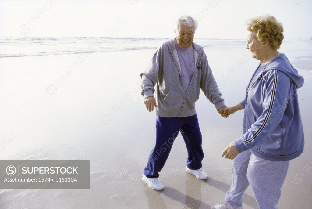 Stock Photo: 1574R-015110A Senior couple standing on the beach