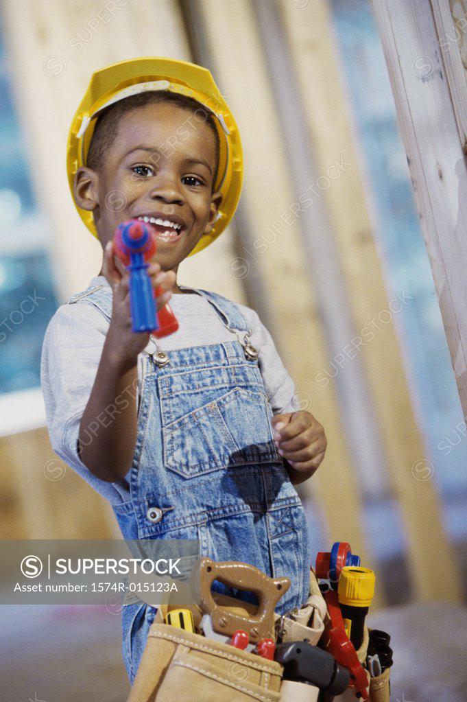 Stock Photo: 1574R-015123A Portrait of a boy dressed as a construction worker holding a toy drill