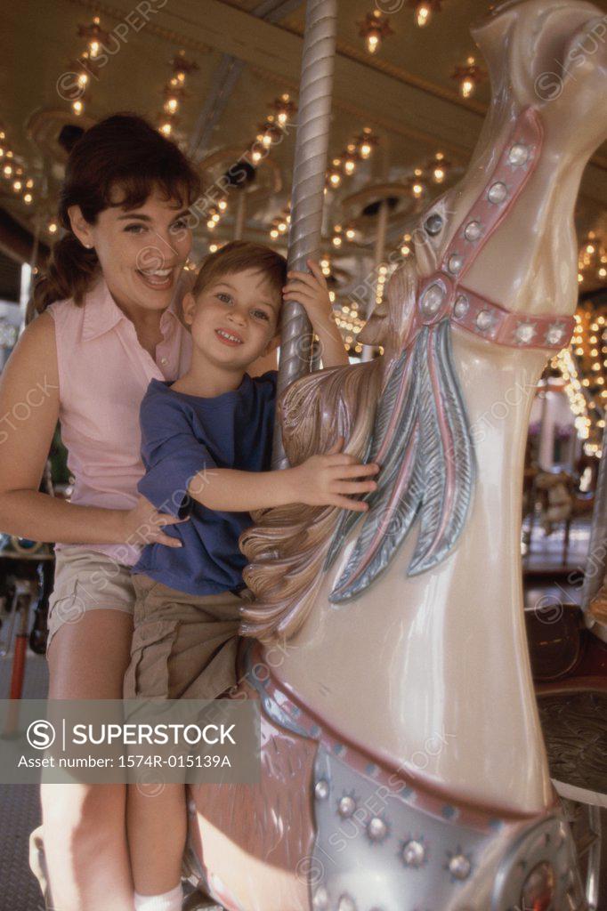 Stock Photo: 1574R-015139A Mother and son riding a carousel horse