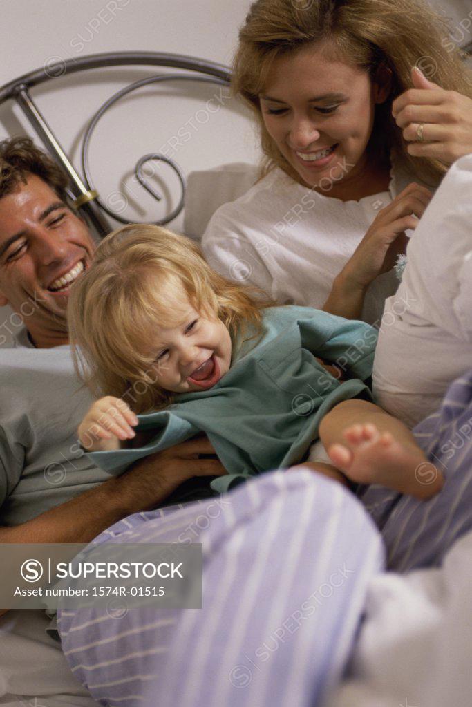 Stock Photo: 1574R-01515 Daughter lying in bed with her parents