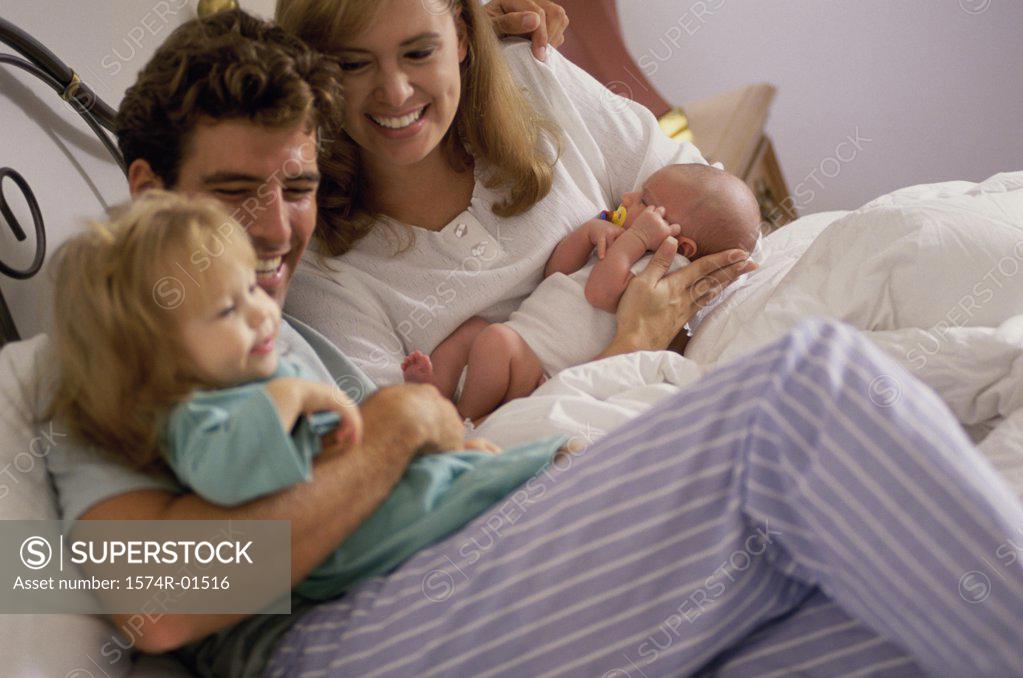 Stock Photo: 1574R-01516 Daughter lying in bed with her parents