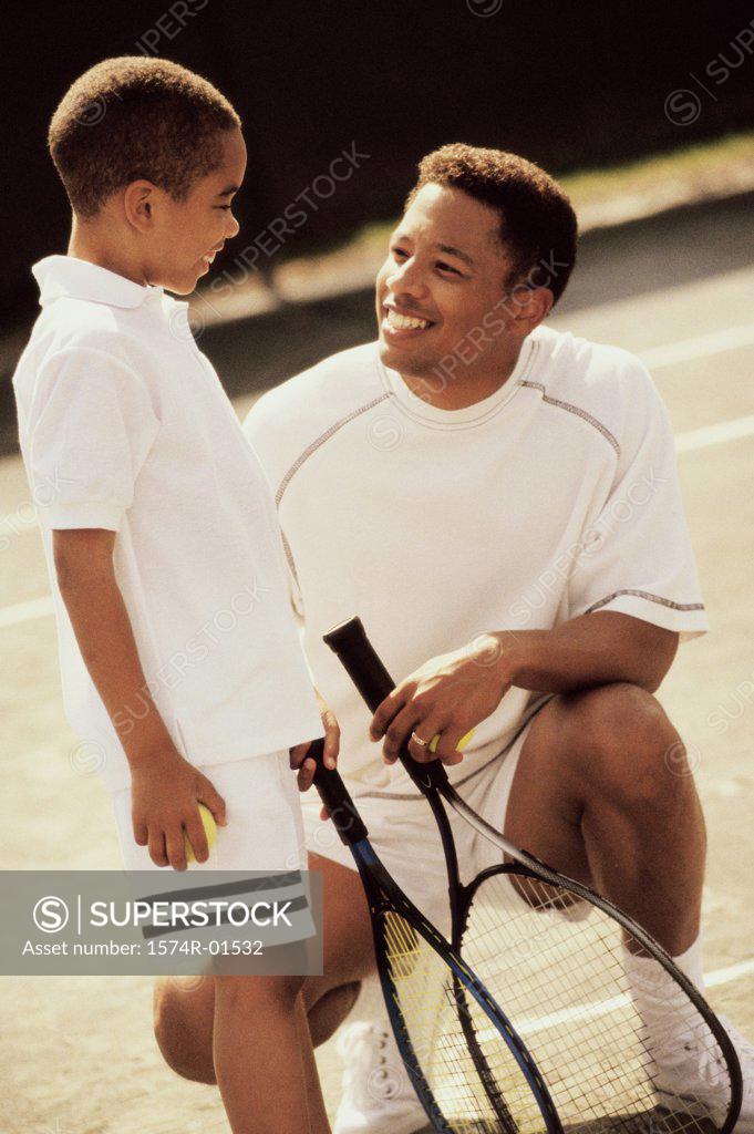 Stock Photo: 1574R-01532 Father and son in tennis outfits holding rackets