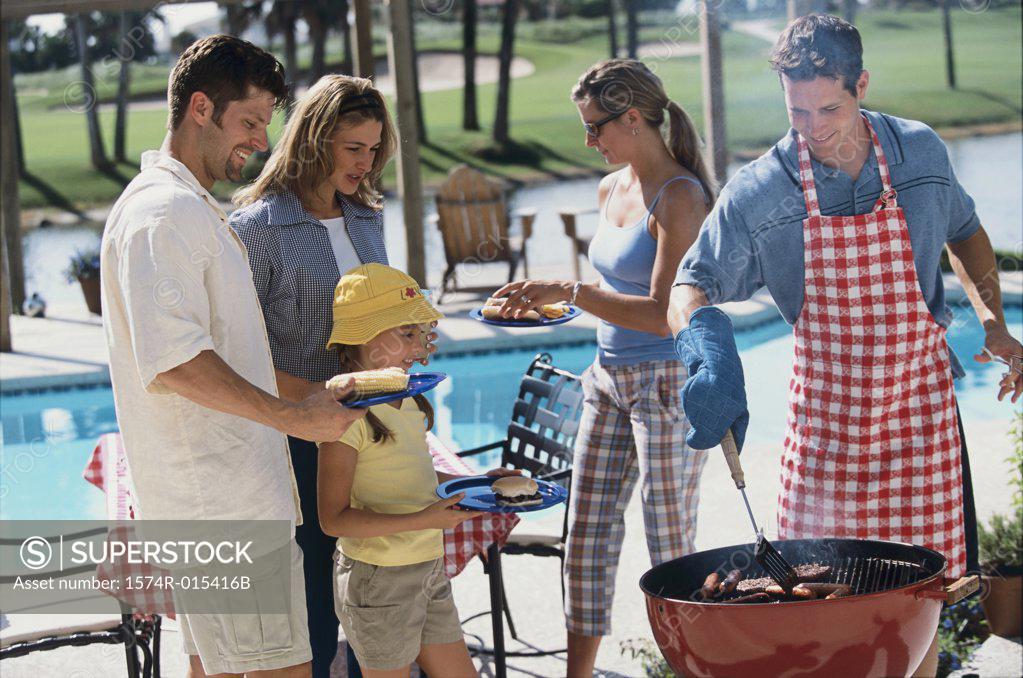 Stock Photo: 1574R-015416B Young man serving hot dogs at a barbecue