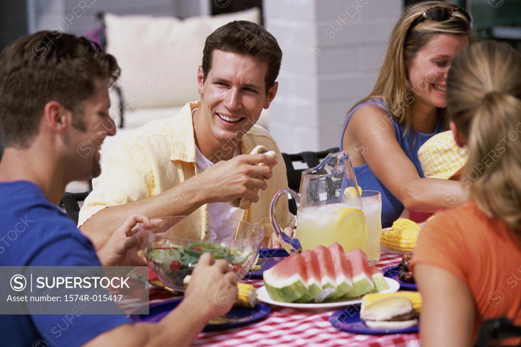 Stock Photo: 1574R-015417 Two young couples sitting around a picnic table