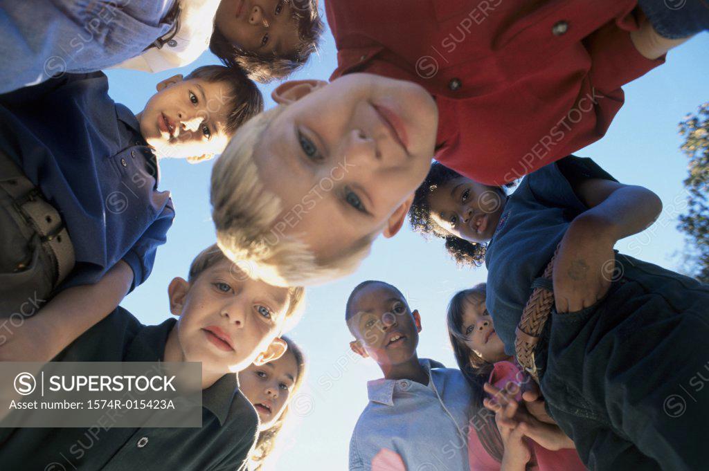 Stock Photo: 1574R-015423A Low angle view of a group of children in a huddle