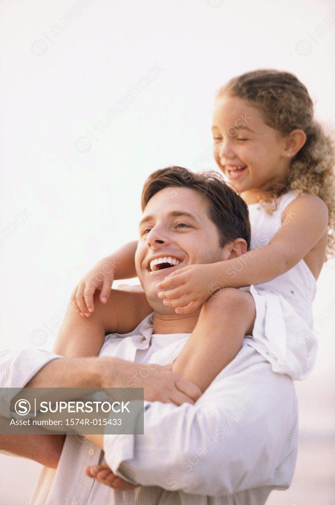 Stock Photo: 1574R-015433 Close-up of a father carrying his daughter on his shoulders
