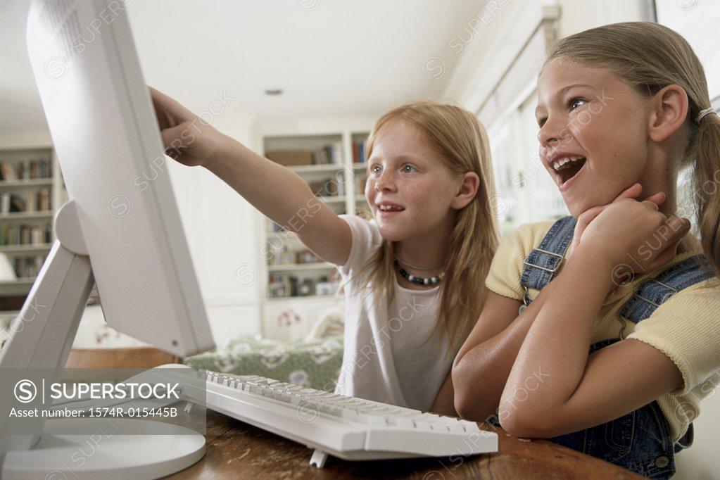 Stock Photo: 1574R-015445B Close-up of two girls pointing to a computer monitor