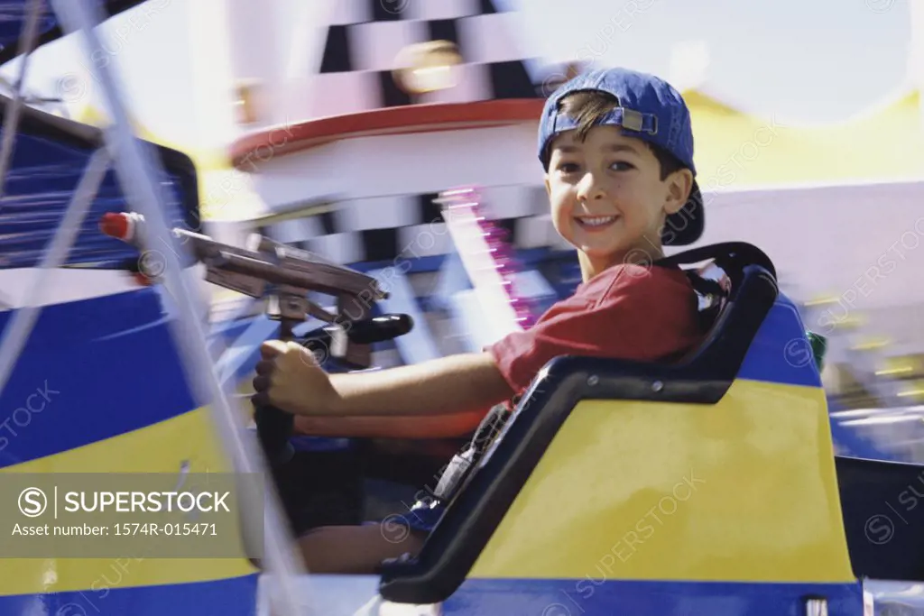 Portrait of a boy sitting on an amusement park ride
