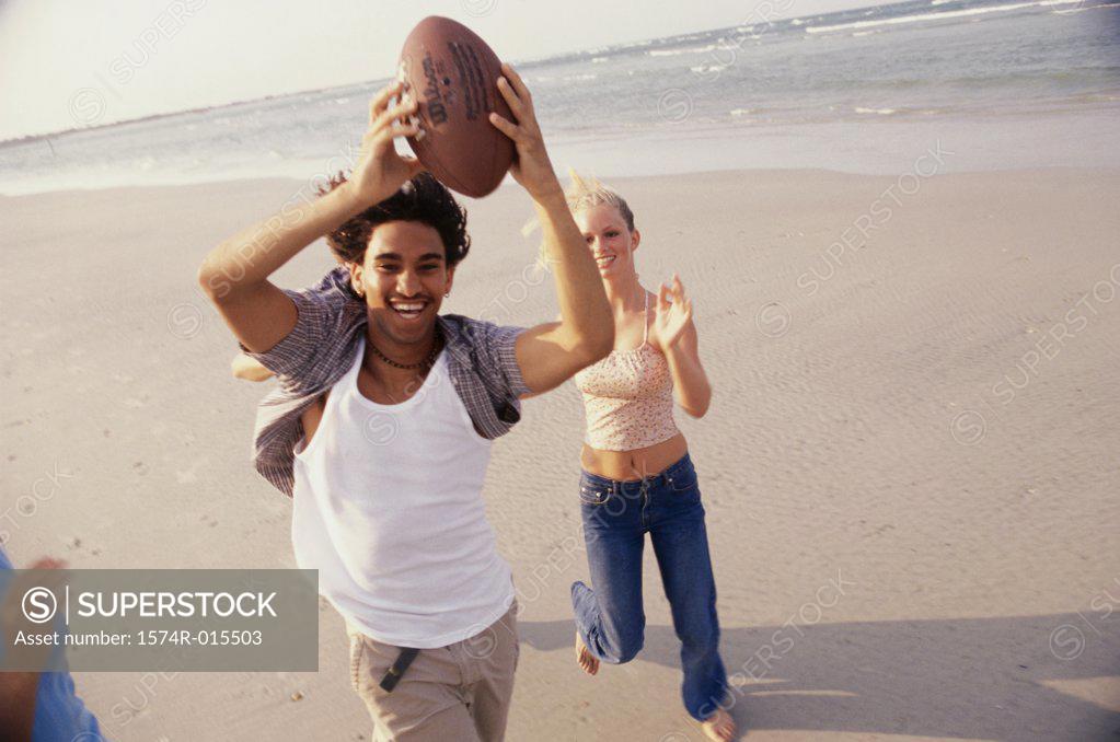 Stock Photo: 1574R-015503 High angle view of a teenage couple playing football on the beach