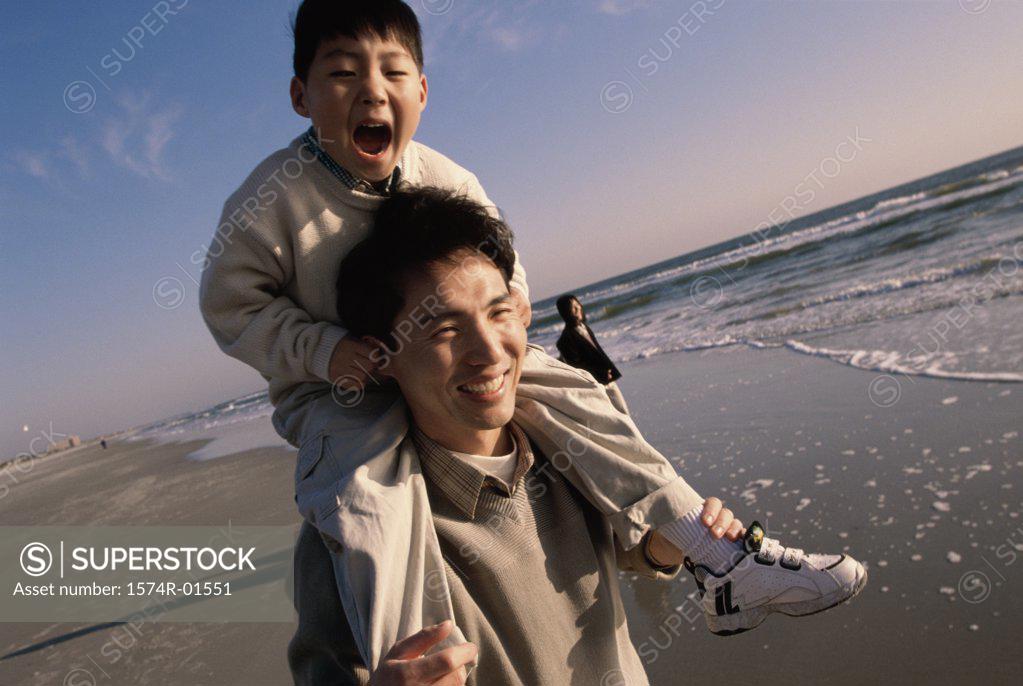 Stock Photo: 1574R-01551 Close-up of a man carrying his son on his shoulders at the beach