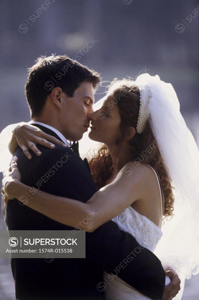 Stock Photo: 1574R-015538 Side profile of a newlywed couple kissing