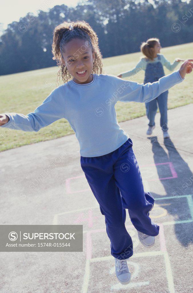 Stock Photo: 1574R-015544 Two girls playing hopscotch