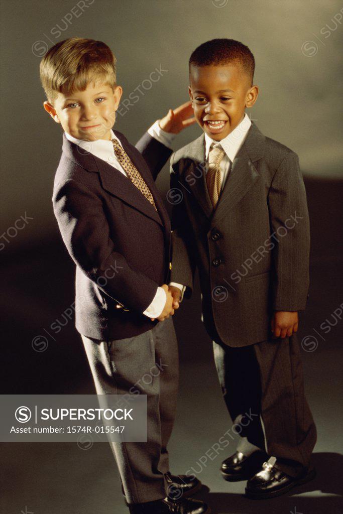 Stock Photo: 1574R-015547 Portrait of two boys dressed as businessmen shaking hands