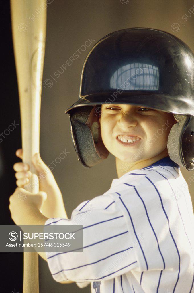 Stock Photo: 1574R-015549 Boy in a baseball uniform holding a baseball bat