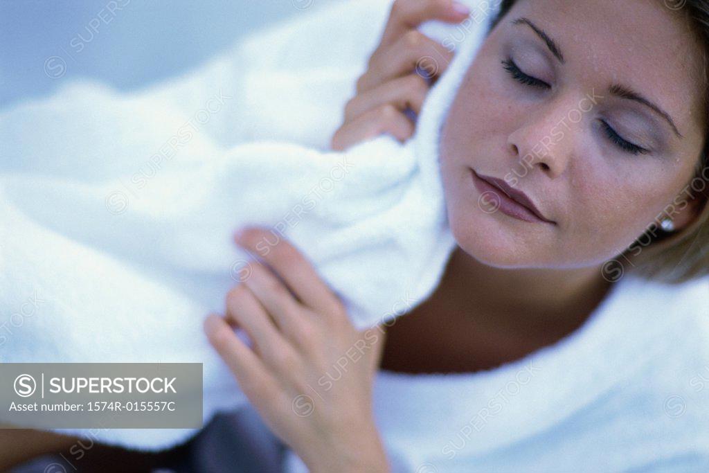 Stock Photo: 1574R-015557C Young woman wiping her face with a towel