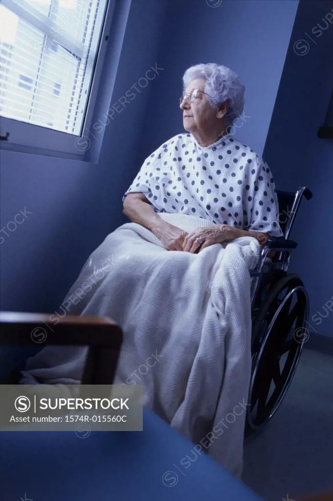 Female patient sitting in a wheelchair looking out of a window