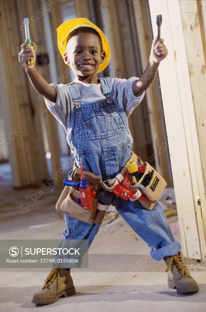 Stock Photo: 1574R-015580A Portrait of a boy dressed as a construction worker holding two toy screwdrivers