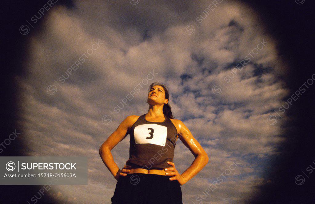 Stock Photo: 1574R-015603A Low angle view of a woman standing with her hands on her hips