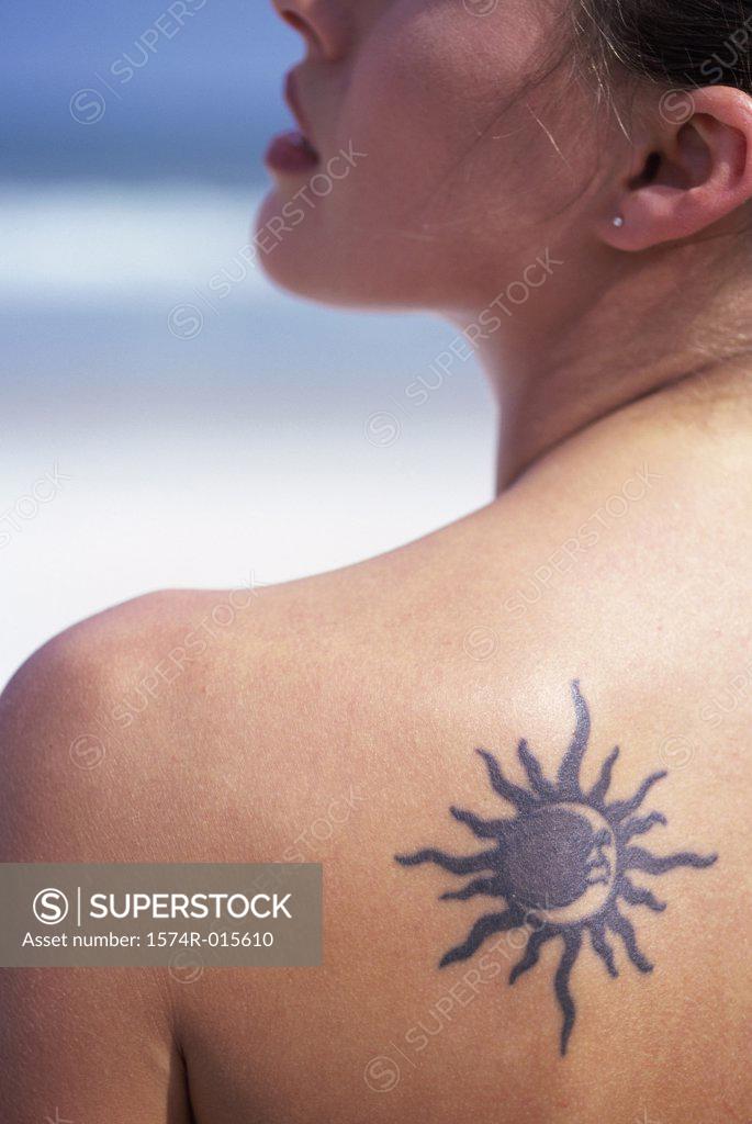 Stock Photo: 1574R-015610 Rear view of a young woman with a tattoo on her back