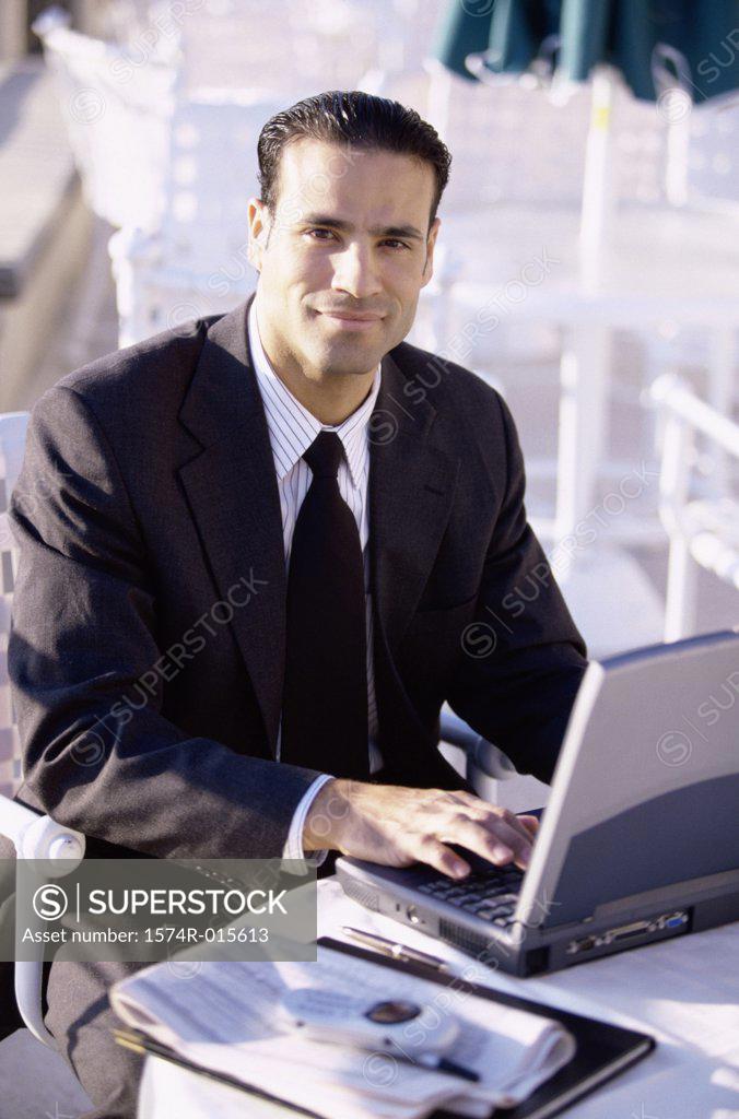 Stock Photo: 1574R-015613 Portrait of a businessman sitting in front of a laptop