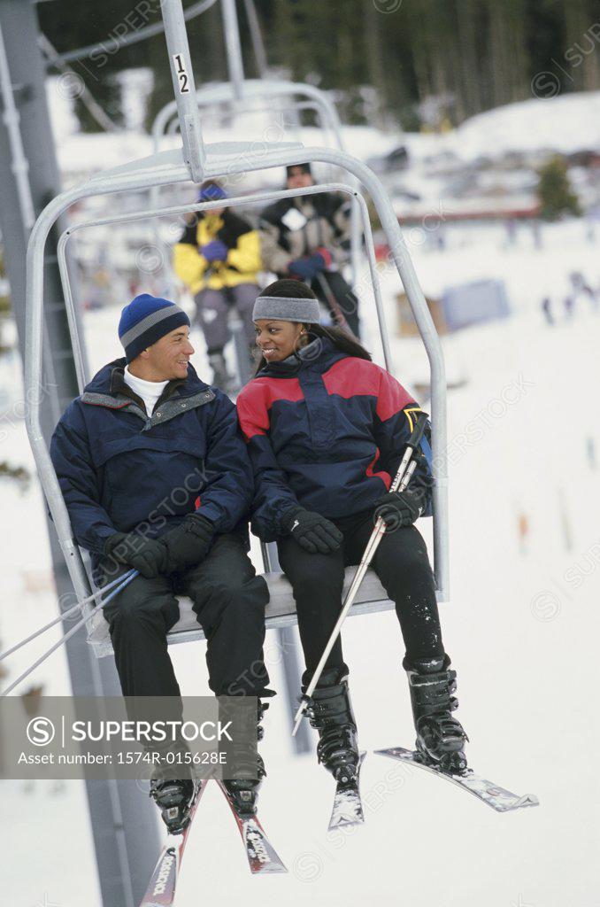 Stock Photo: 1574R-015628E Young couple sitting on a ski lift