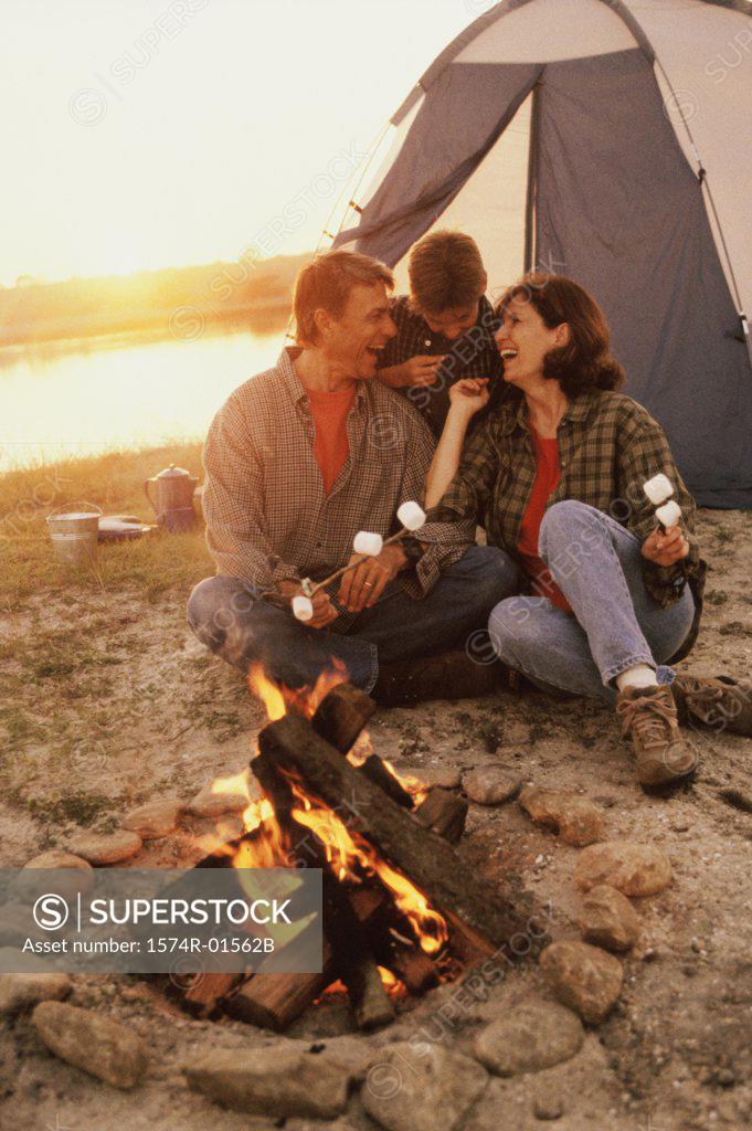 Stock Photo: 1574R-01562B Father and mother with their son in front of a campfire on the beach