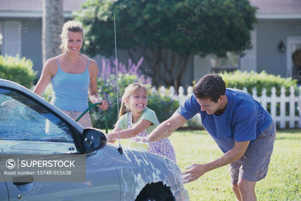 Stock Photo: 1574R-01563B Parents and their daughter washing a car