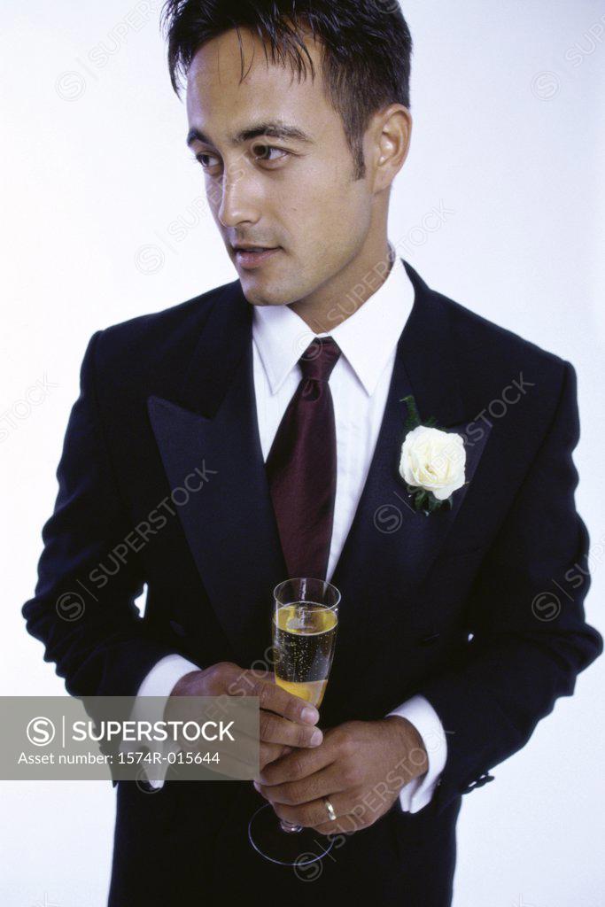 Stock Photo: 1574R-015644 Young man holding a champagne flute