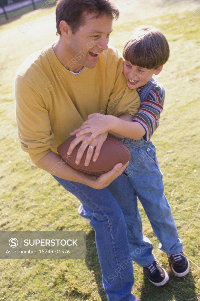 Stock Photo: 1574R-01576 Father and son playing football