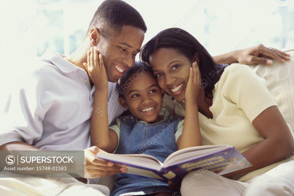 Stock Photo: 1574R-01583 Parents and their daughter sitting together on a couch