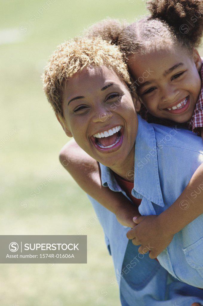 Stock Photo: 1574R-01606A Portrait of a woman carrying her daughter on her back
