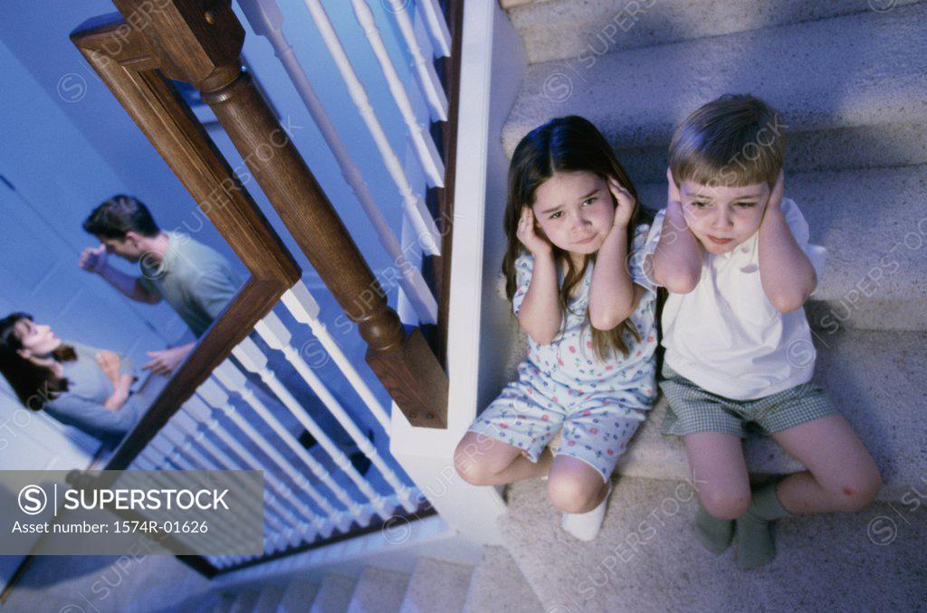Stock Photo: 1574R-01626 High angle view of a boy and girl listening to their parents fight