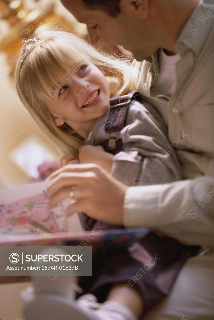 Stock Photo: 1574R-01637B Close-up of a father reading to his daughter