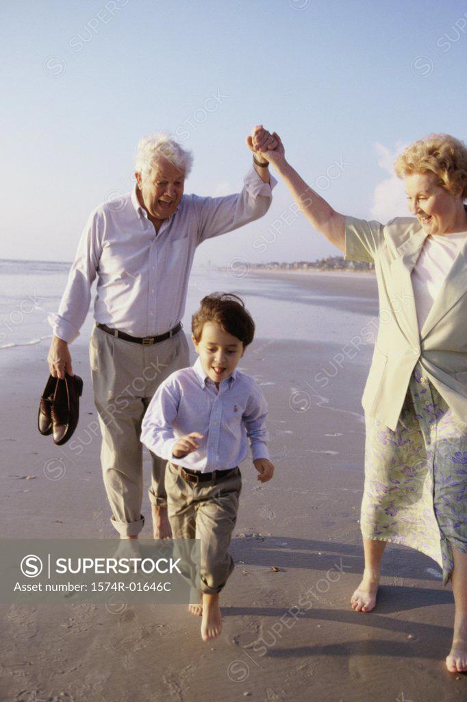 Stock Photo: 1574R-01646C Boy playing on the beach with his grandparents