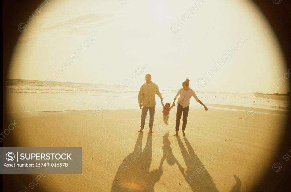 Stock Photo: 1574R-01657B Father and mother with their daughter at the beach