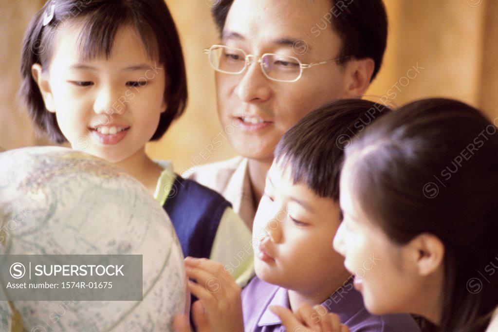 Stock Photo: 1574R-01675 Close-up of a couple looking at a globe with their son and daughter