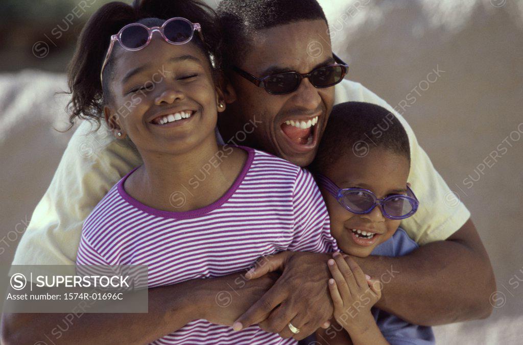 Stock Photo: 1574R-01696C Man hugging his son and daughter on the beach