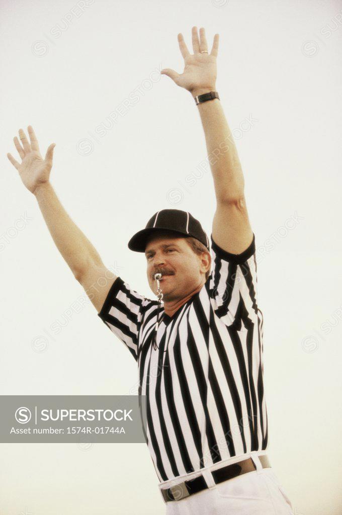 Stock Photo: 1574R-01744A Football referee whistling with his arms raised