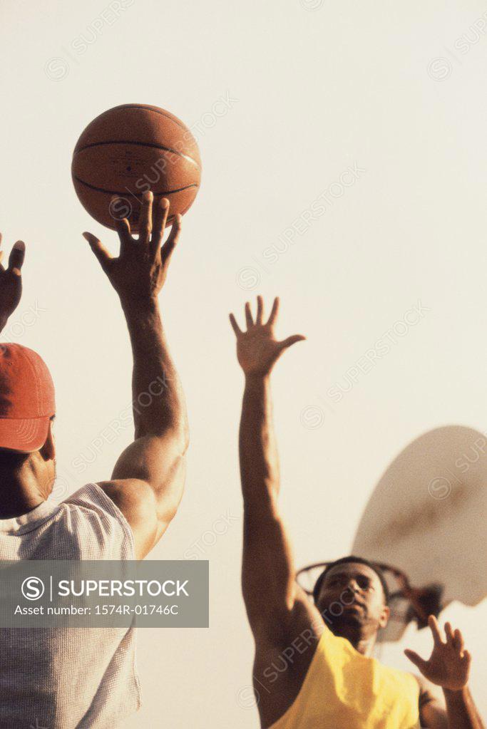 Stock Photo: 1574R-01746C Low angle view of two men playing basketball