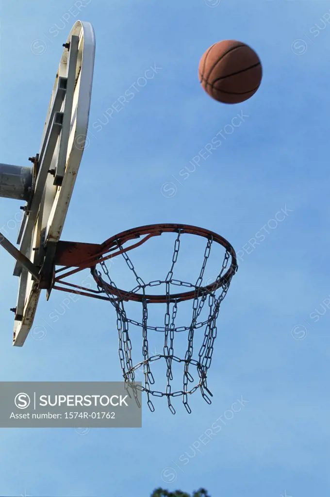 Low angle view of a basketball bouncing off the hoop