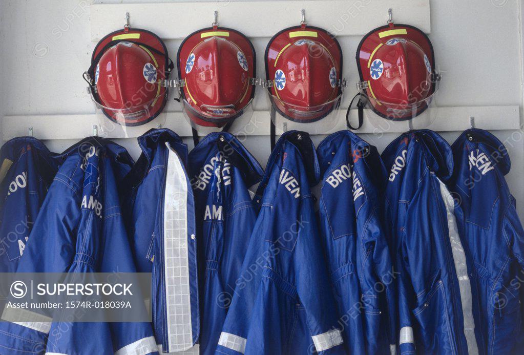 Stock Photo: 1574R-018039A Close-up of fire fighter's helmets and fire protective suits hanging on hooks