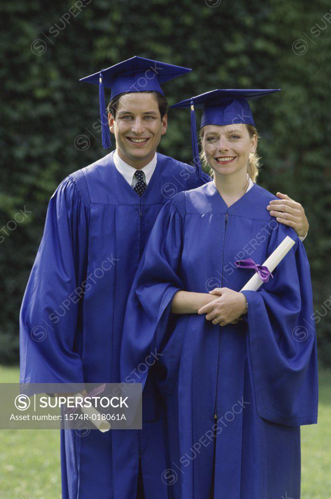 Stock Photo: 1574R-018061A Two young graduates standing together in a garden