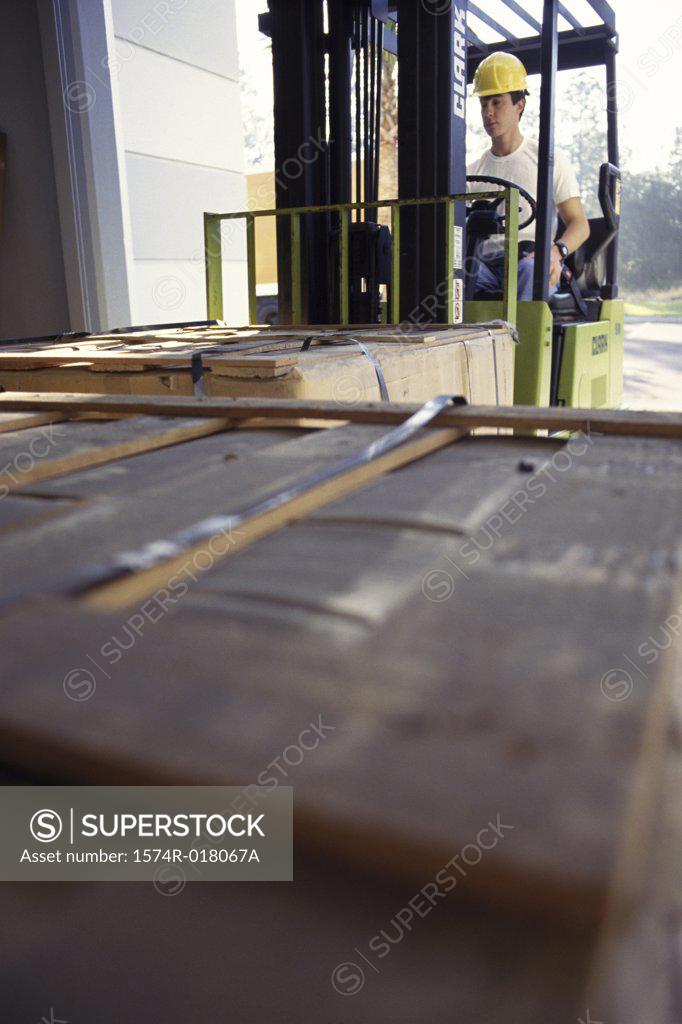 Stock Photo: 1574R-018067A Young man sitting in a forklift