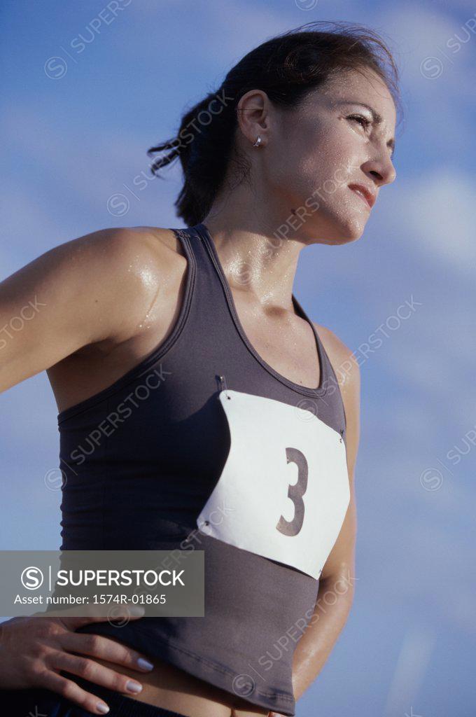 Stock Photo: 1574R-01865 Low angle view of a woman standing with her hands on her hips