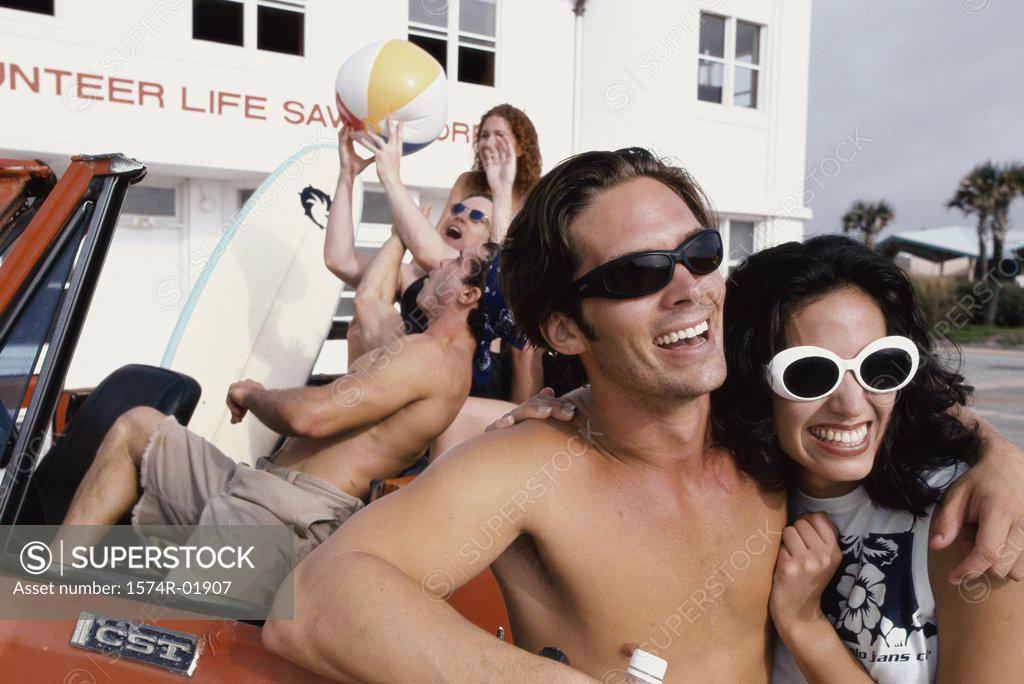 Stock Photo: 1574R-01907 Young men and women in a car with surfboards