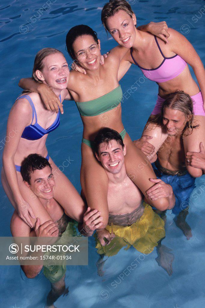 Stock Photo: 1574R-01934 Group of teenage girls sitting on teenage boys shoulders in the water