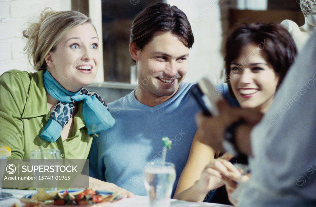 Stock Photo: 1574R-01965 Close-up of a young man in a cafe with two young women