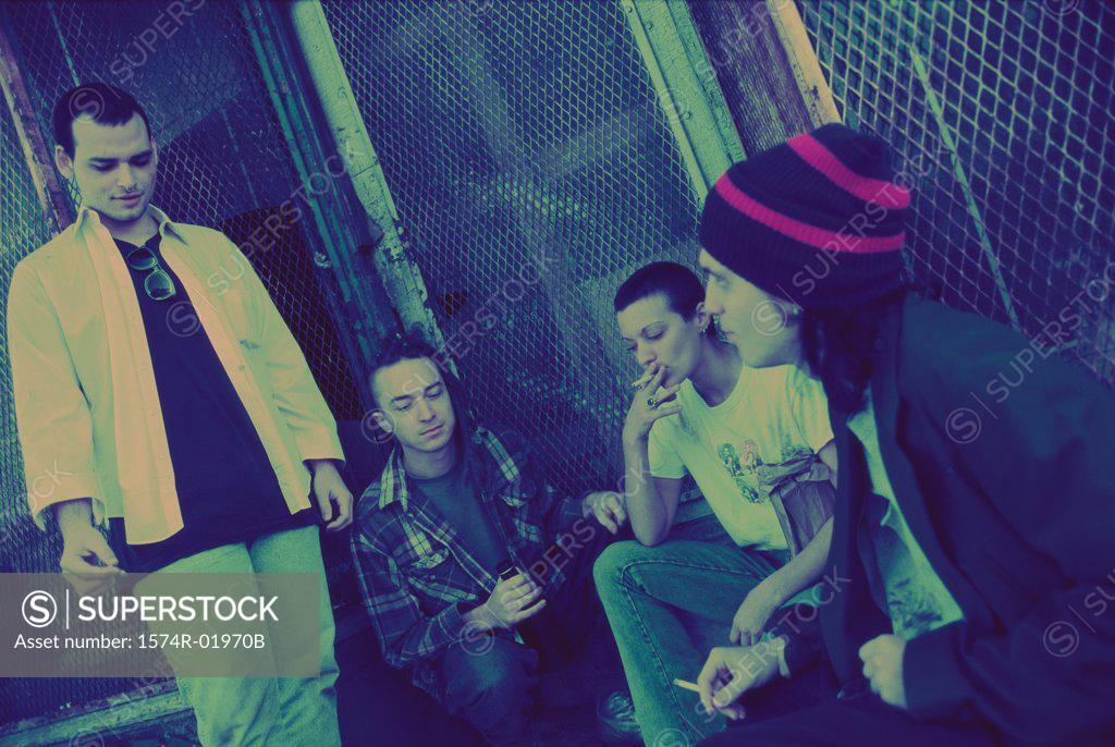Stock Photo: 1574R-01970B Young men and women smoking on a sidewalk